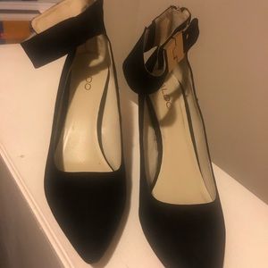Black heels ties around the ankle with gold buckle